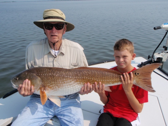 This giant redfish was caught by my 12 year old son Dylan. My dad had to help him hold the fish for the picture. The fish was taken on blue crab and light tackle. We were fishing the Indian River LAgoon near Titusville Florida. Dylan has now caught 6 redfish over 35 lbs since he was 8 years old.