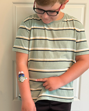 Load image into Gallery viewer, Child wearing a striped shirt with a temporary tattoo on their arm.